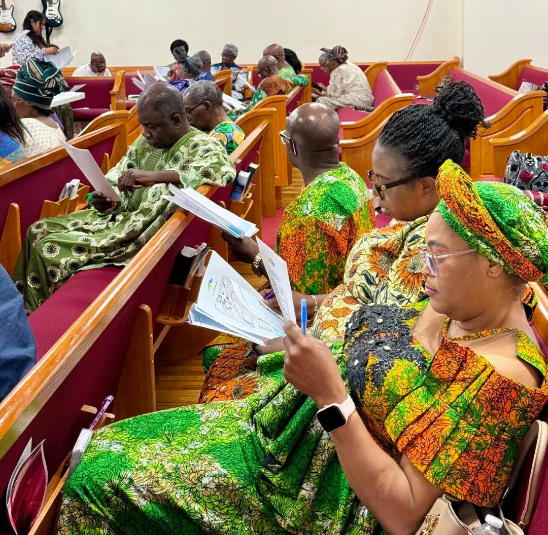 Community members reviewing printed materials during a church-based climate and health workshop.